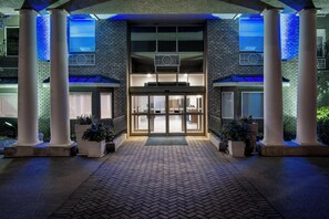 A hotel entrance with a brick facade, large glass doors, and columns.