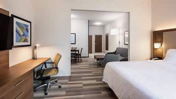 Ein Hotelzimmer mit Bett, Schreibtisch, Stuhl und Essecke.