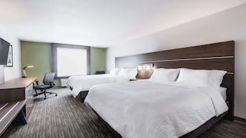 Quarto de hotel com duas camas, uma escrivaninha e uma cadeira.