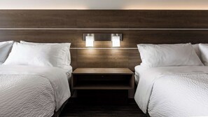 A hotel room with two beds, a wooden headboard, and a nightstand with two wall-mounted lights. - Holiday Inn Express & Suites Regina-South by IHG (Regina)
