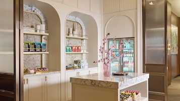 A modern kitchen with marble countertops, wooden cabinetry, and a central island.