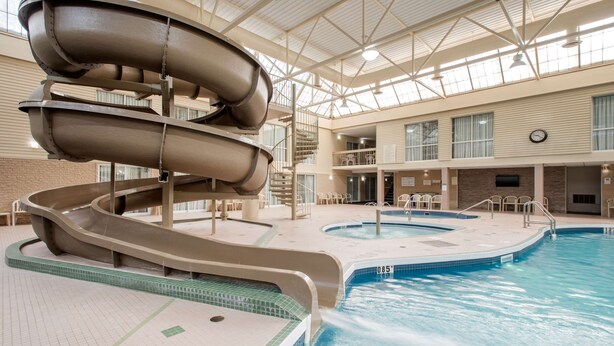 Una piscina interior con tobogán y bañera de hidromasaje.