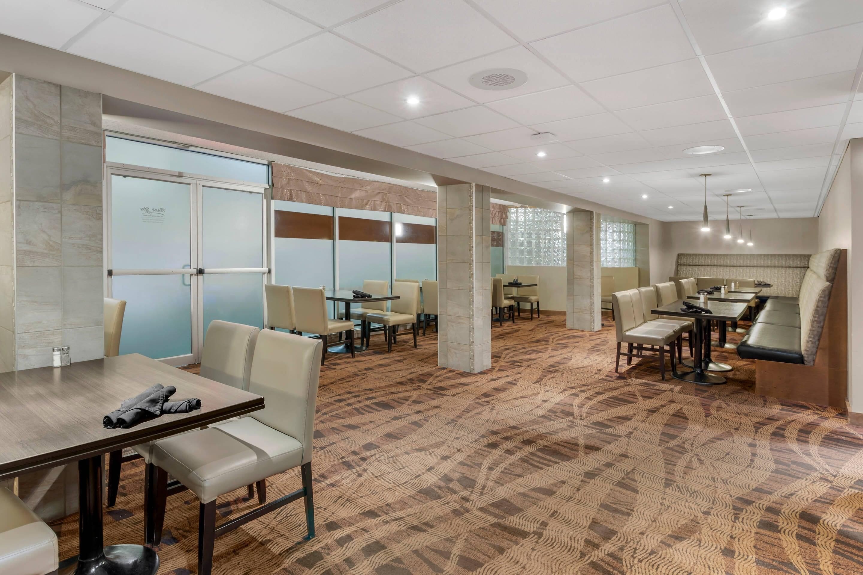 A hotel lobby with a carpeted floor, seating areas, and a reception desk.