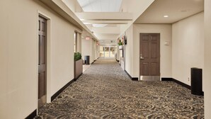 A hotel hallway with patterned carpet, a ceiling with recessed lighting, and a door at the end. - Superior Inn Hotel and Conference Centre Thunder Bay (Thunder Bay)