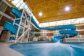 An indoor swimming pool with multiple water slides and a high ceiling with natural light. - Superior Inn Hotel and Conference Centre Thunder Bay (Thunder Bay)