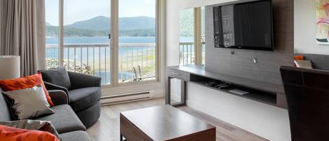 A modern living room with a sofa, coffee table, and a TV mounted on the wall.