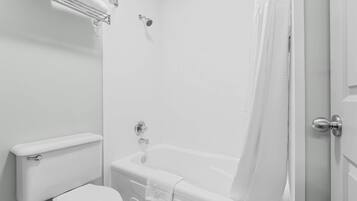 Ein Badezimmer mit Toilette, Badewanne, Handtuch und Duschvorhang.