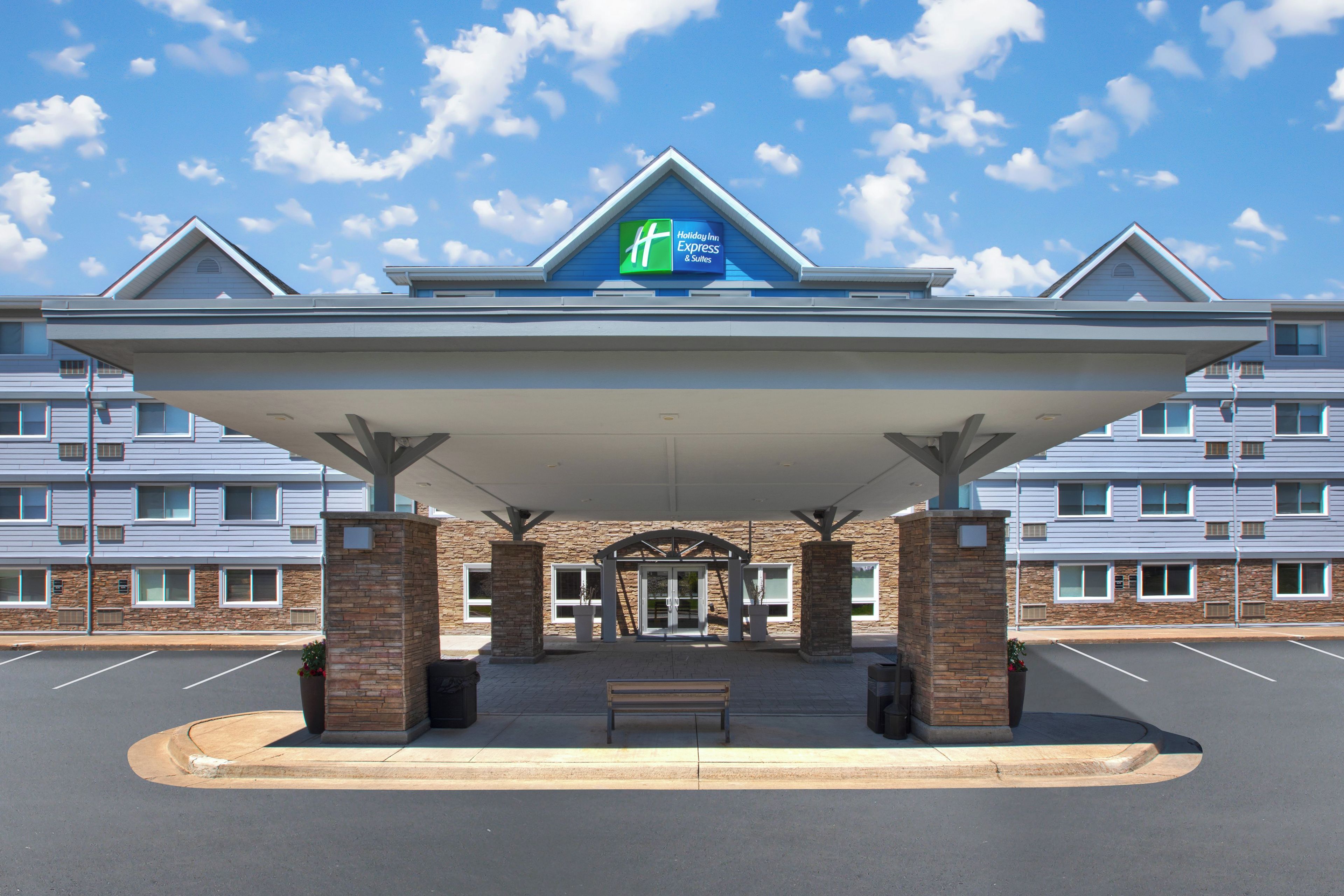 A Holiday Inn Express & Suites hotel with a covered entrance and a parking lot.