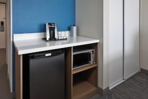 A compact kitchenette with a coffee maker, a microwave, and a dishwasher.
