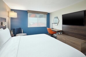 A hotel room with a bed, a desk, an orange chair, a flat-screen TV, and a window with a view. - Holiday Inn Express & Suites Fredericton by IHG (Fredericton)