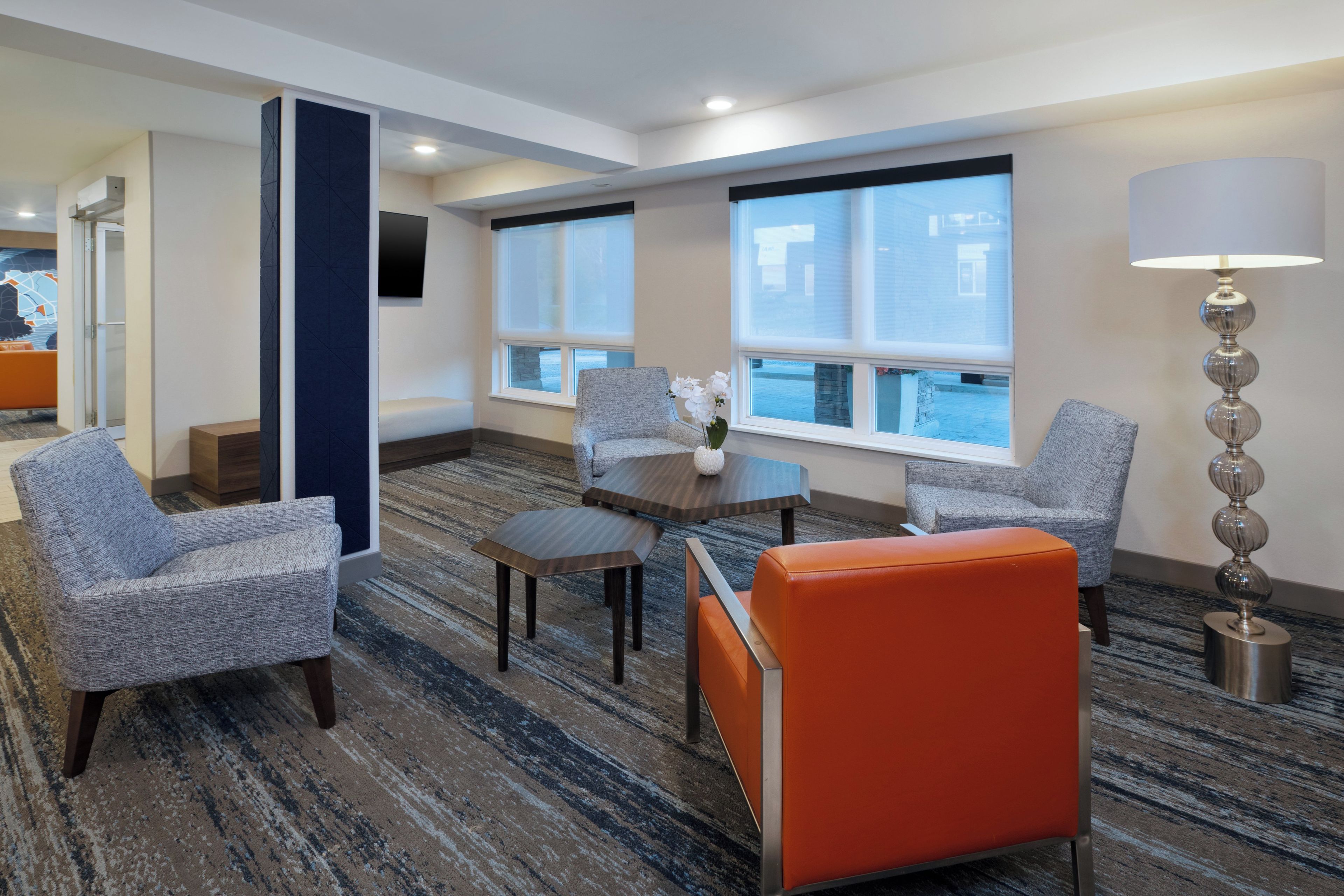 Habitación de hotel con zona de estar, una mesa y una lámpara.