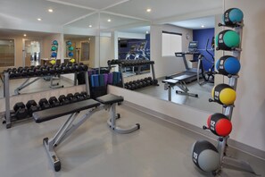 A gym with exercise equipment, mirrors, and a treadmill. - Holiday Inn Express & Suites Fredericton by IHG (Fredericton)