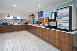 A modern kitchen with wooden cabinets, a breakfast bar, and a refrigerator stocked with dairy products.