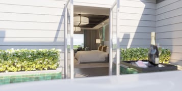 Habitación de hotel con cama, mesita de noche, lámpara y vistas al exterior.