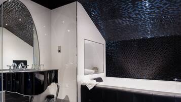 Une salle de bain moderne avec un grand miroir, un meuble-lavabo noir et une baignoire.