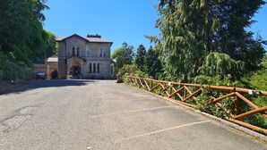 A stone building with a large driveway and a wooden fence. - Mansfield House Hotel (Hawick)