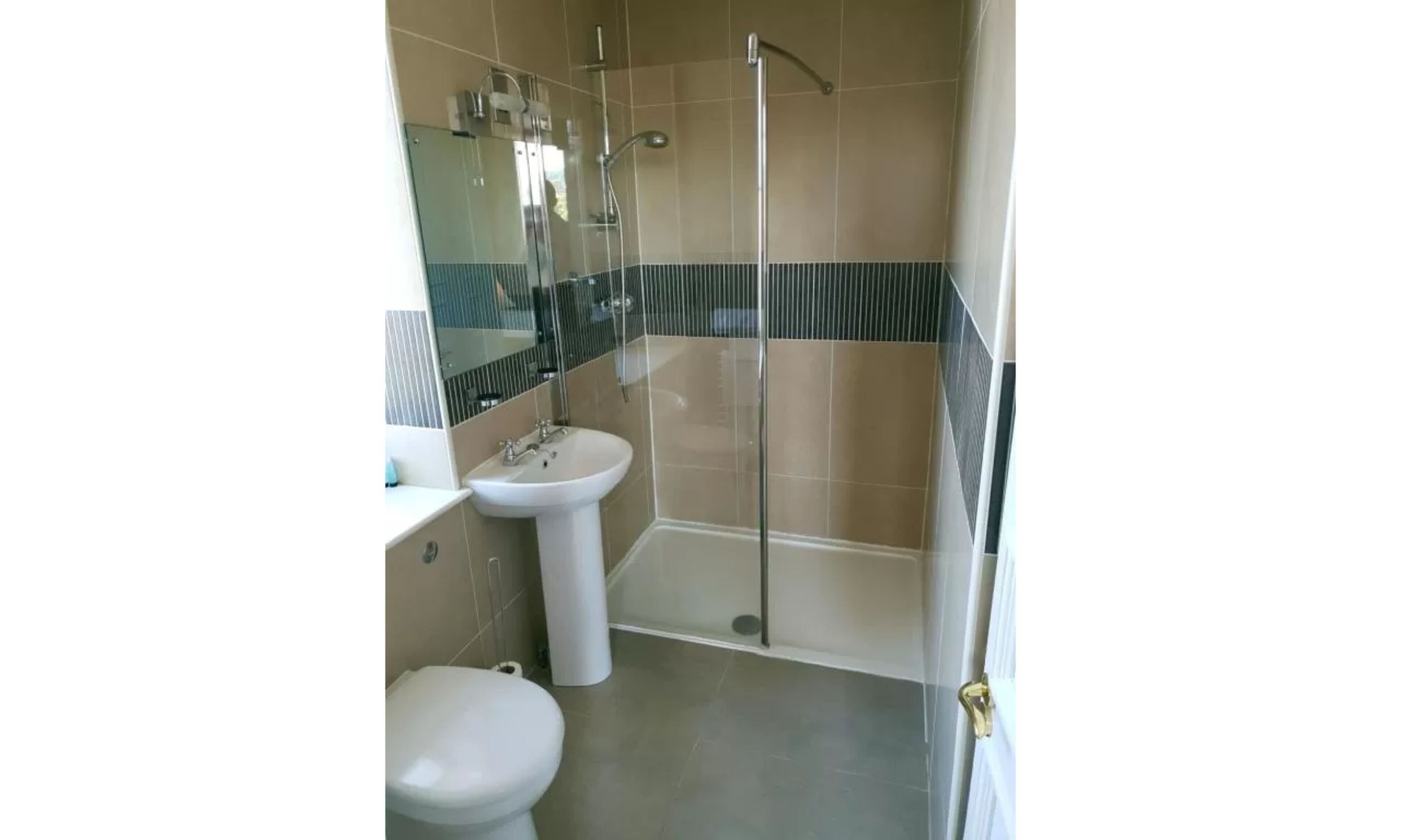 A bathroom with a toilet, sink, and glass-enclosed shower.