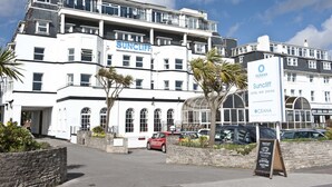 Un hôtel à plusieurs étages, reconnaissable à son grand panneau « SUNCLIFF », qui présente une architecture moderne avec des balcons et de grandes fenêtres.