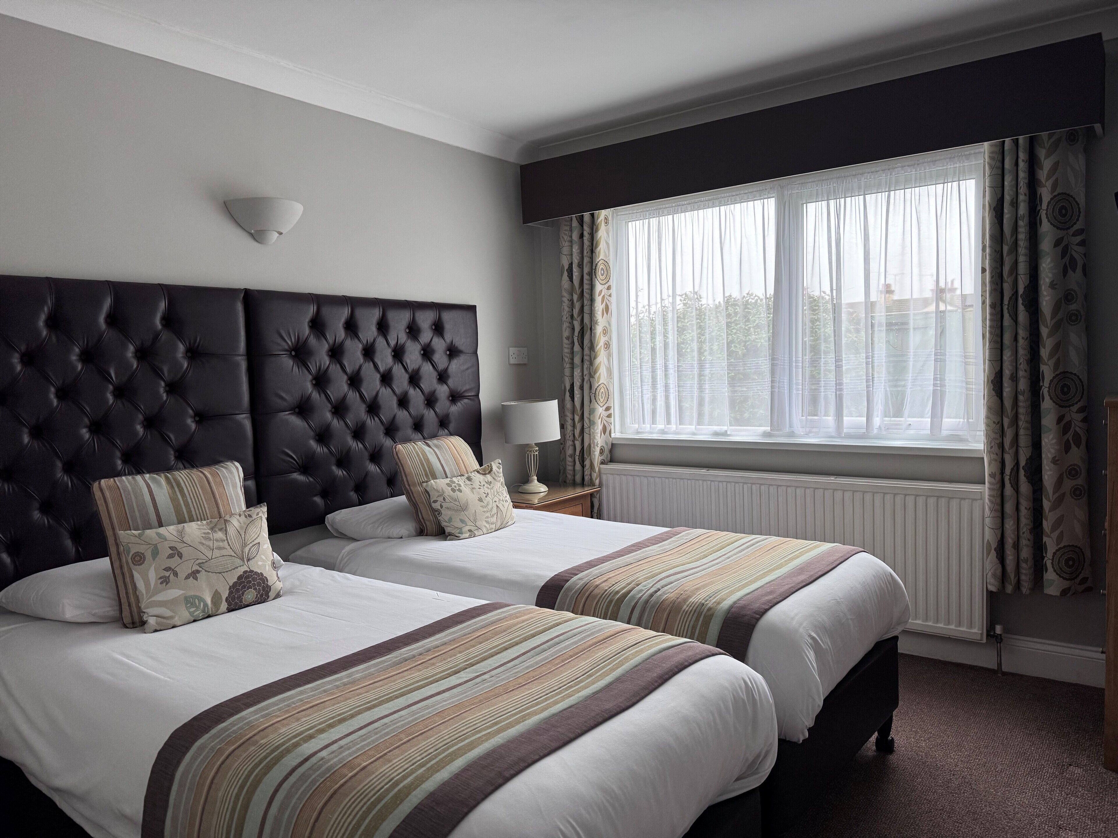 Habitación con 2 camas individuales | Ropa de cama hipoalergénica, escritorio y cortinas blackout 