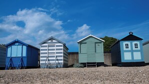 A row of beach huts with a clear sky above. - Camelia Hotel (Southend-on-Sea)