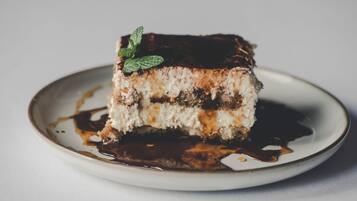 Una porción de pastel con capas y una decoración de menta en un plato.