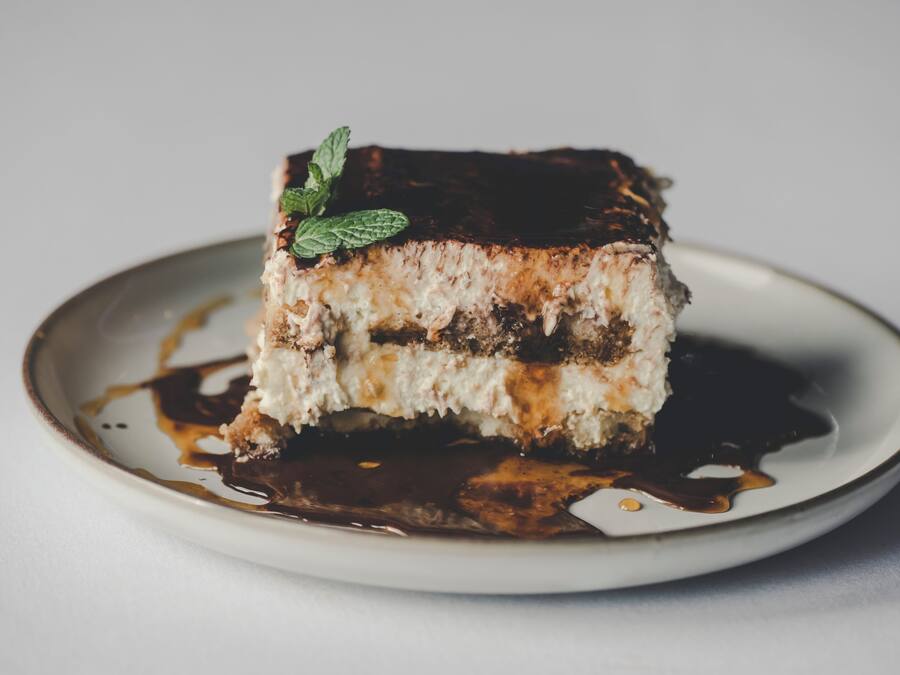 Una porción de pastel con capas y una decoración de menta en un plato.
