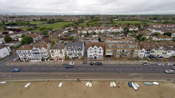 Un quartier résidentiel avec des maisons, une route et une plage où l’on peut faire du surf.
