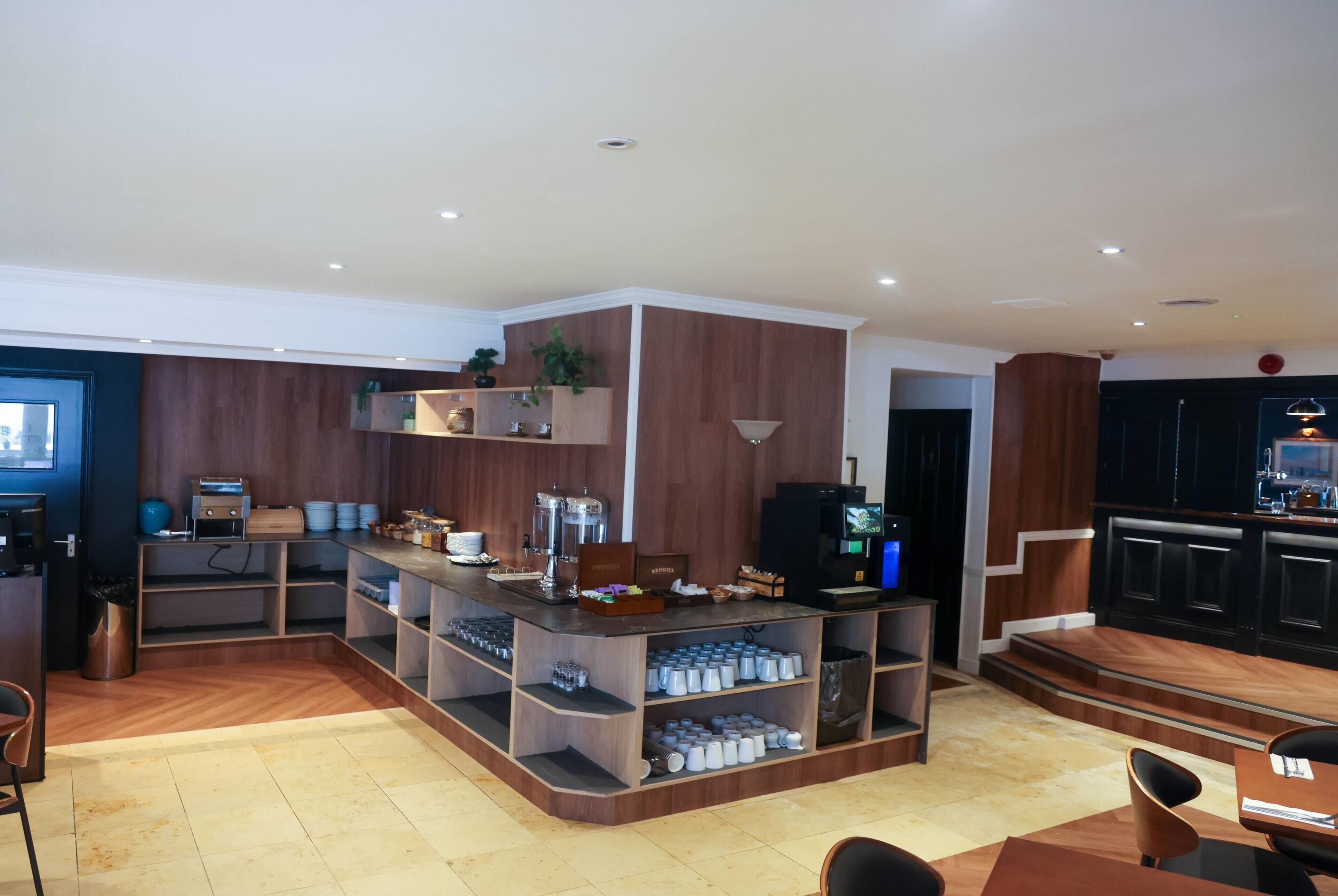 A modern kitchen with built-in appliances, a coffee station, and a seating area with chairs and a table.
