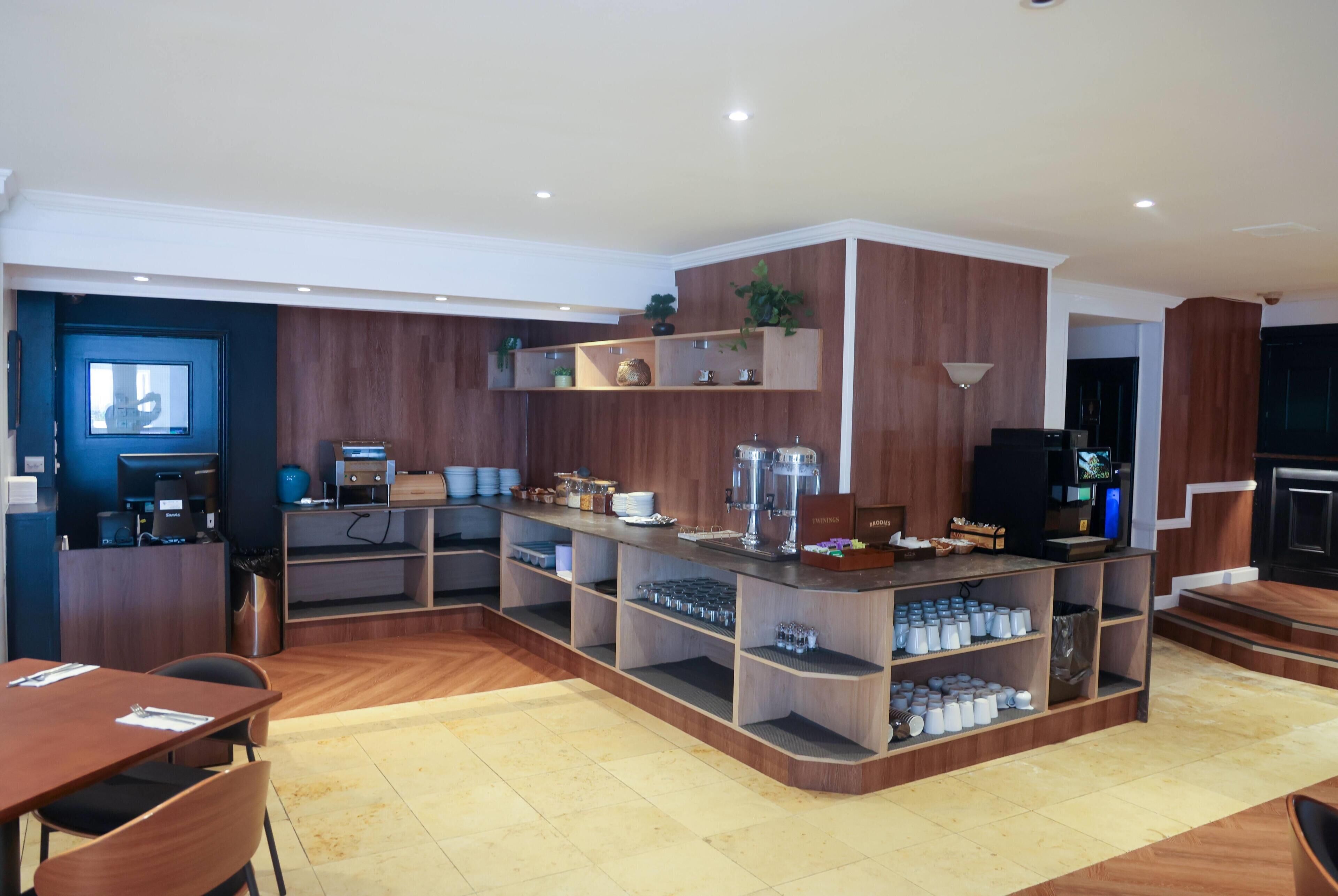 A modern kitchen with built-in shelves, a coffee machine, and a TV.
