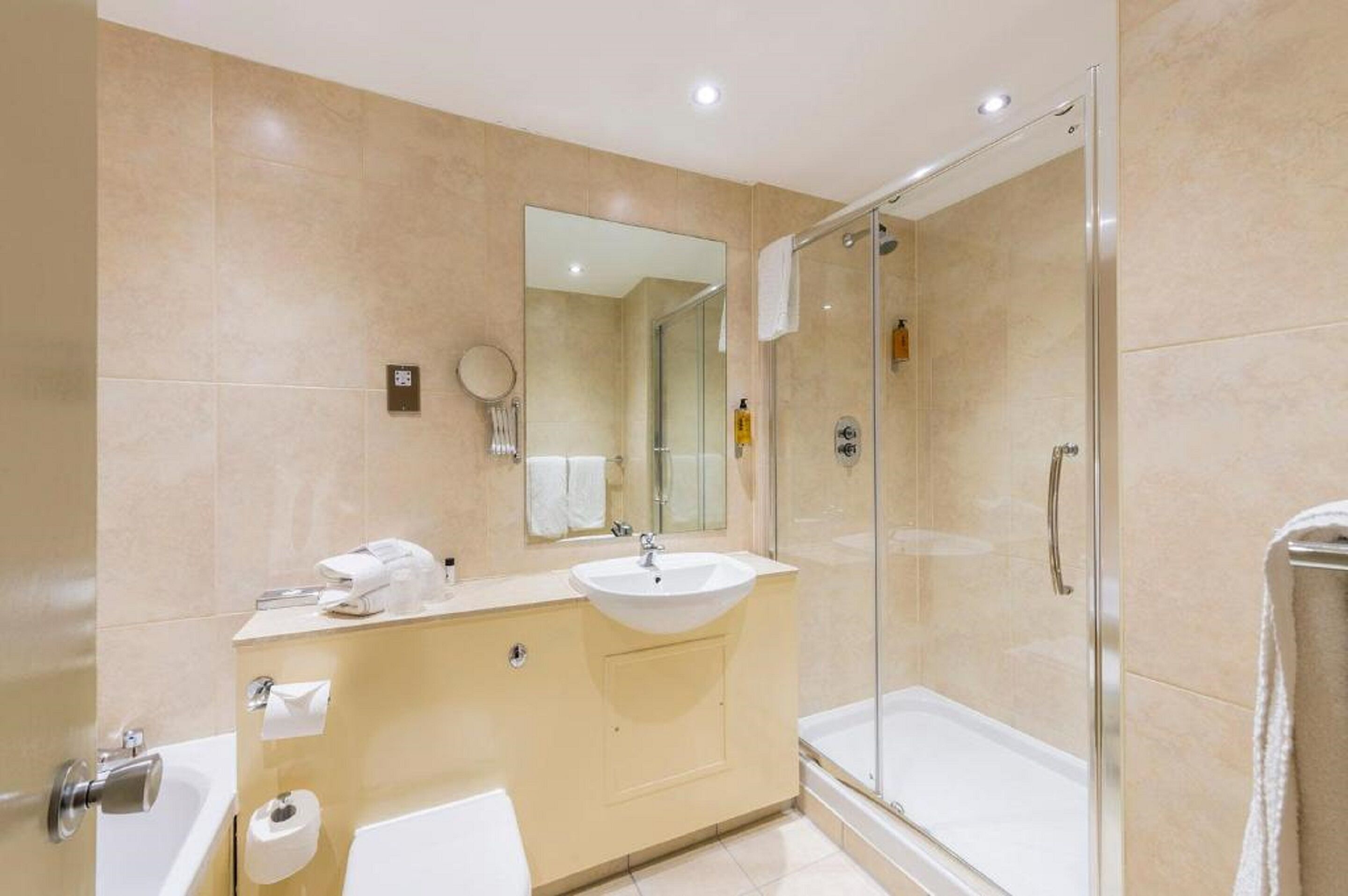 A modern bathroom with a glass shower enclosure, a sink, and a toilet.