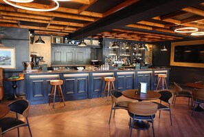 A bar area with wooden beams, bar stools, and a counter with various bottles and glasses. - Ramada by Wyndham Cheltenham (Cheltenham)