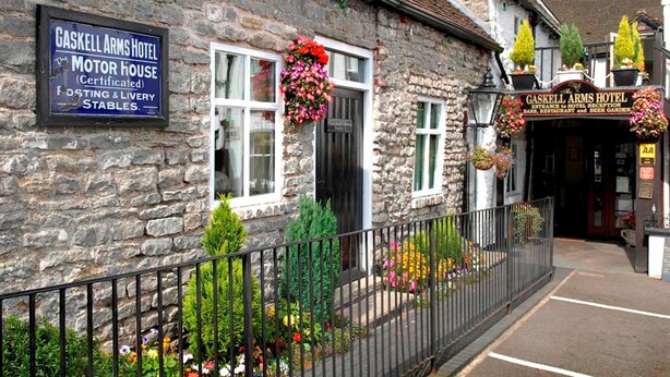 A stone building with a sign for Gaskell Arms Hotel and a Motor House. - The Gaskell Arms Hotel (Much Wenlock)