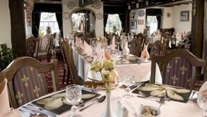 A dining area with round tables set for a meal, featuring white tablecloths, plates, and cutlery. - The Gaskell Arms Hotel (Much Wenlock)