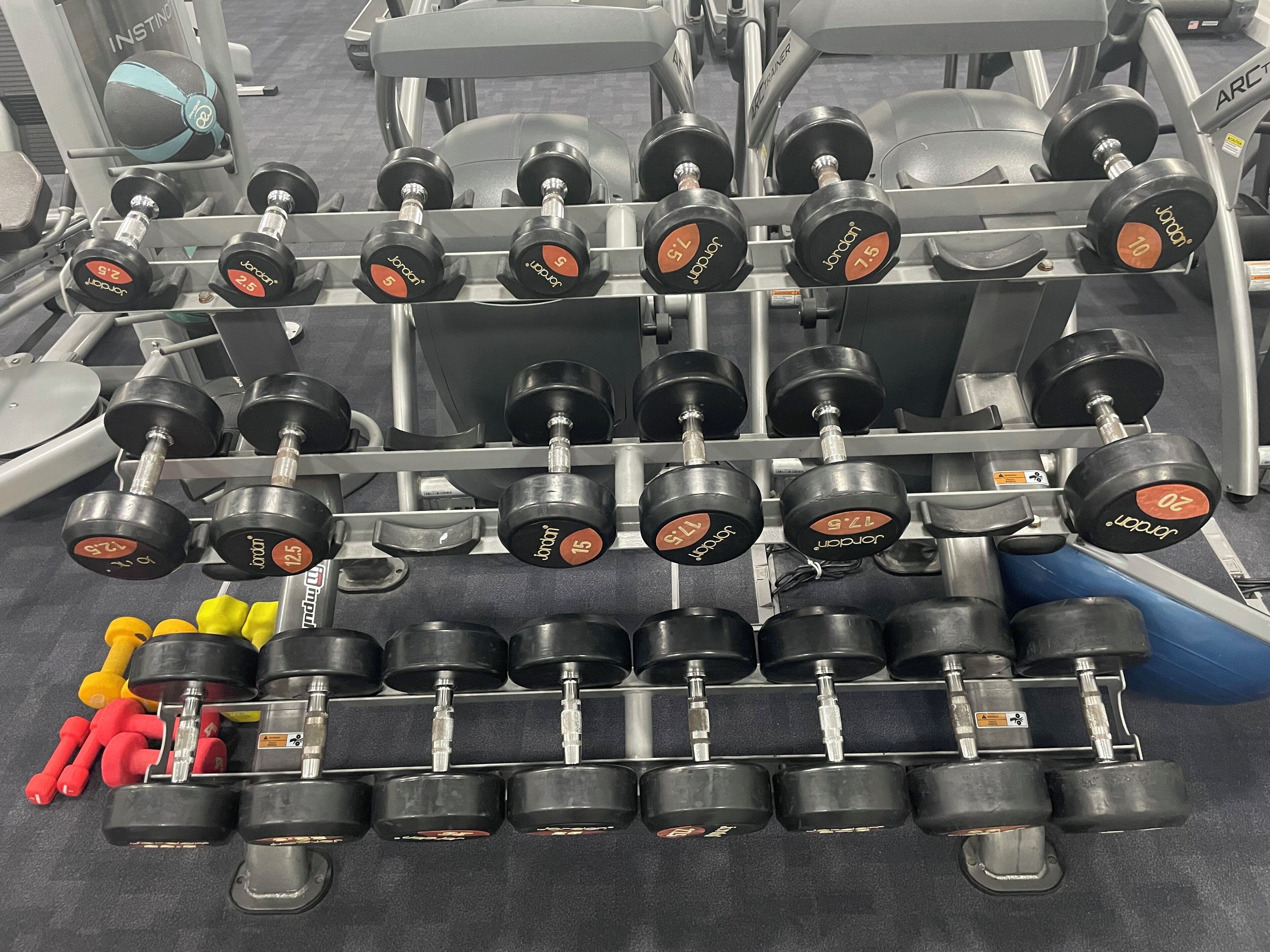 A rack of dumbbells with weights ranging from 2.5 to 20 lbs.
