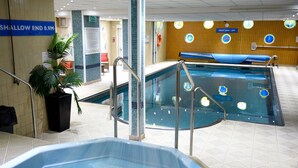Una piscina interior amb una zona poc profunda, un banyera d'hidromassatge i un paviment de rajoles.