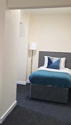 A hotel room with a bed, a bedside lamp, and a carpeted floor. - Devonshire House Hotel-Free Parking (Liverpool)