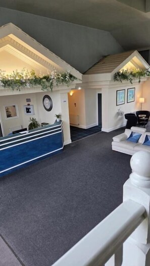 A hotel lobby with a reception desk, seating area, and a staircase. - Devonshire House Hotel-Free Parking (Liverpool)