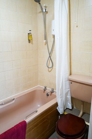 Un baño con bañera, inodoro y ducha.