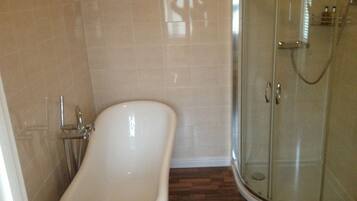 A bathroom with a bathtub, toilet, and glass shower enclosure.