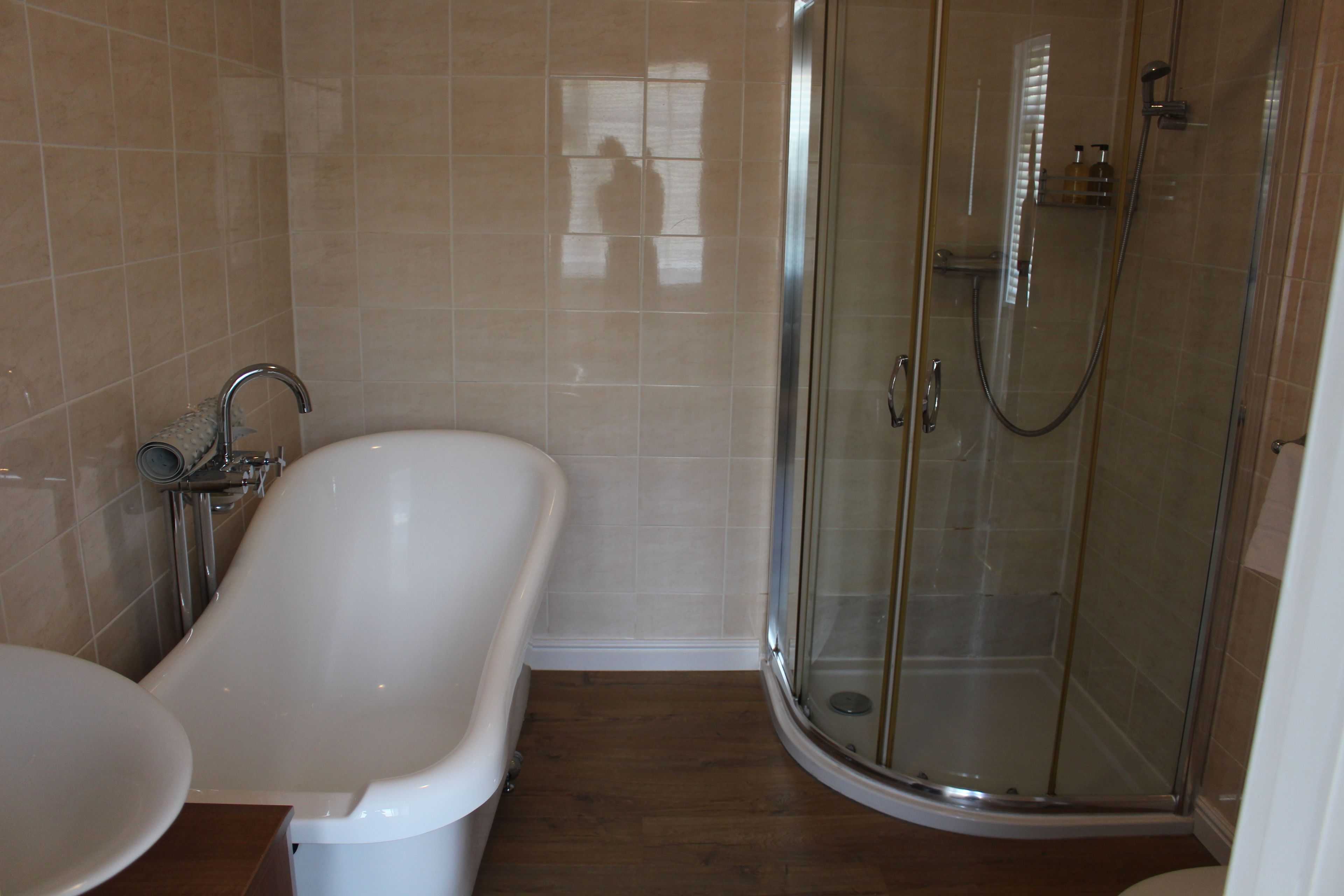 A bathroom with a bathtub, a shower, and a sink.