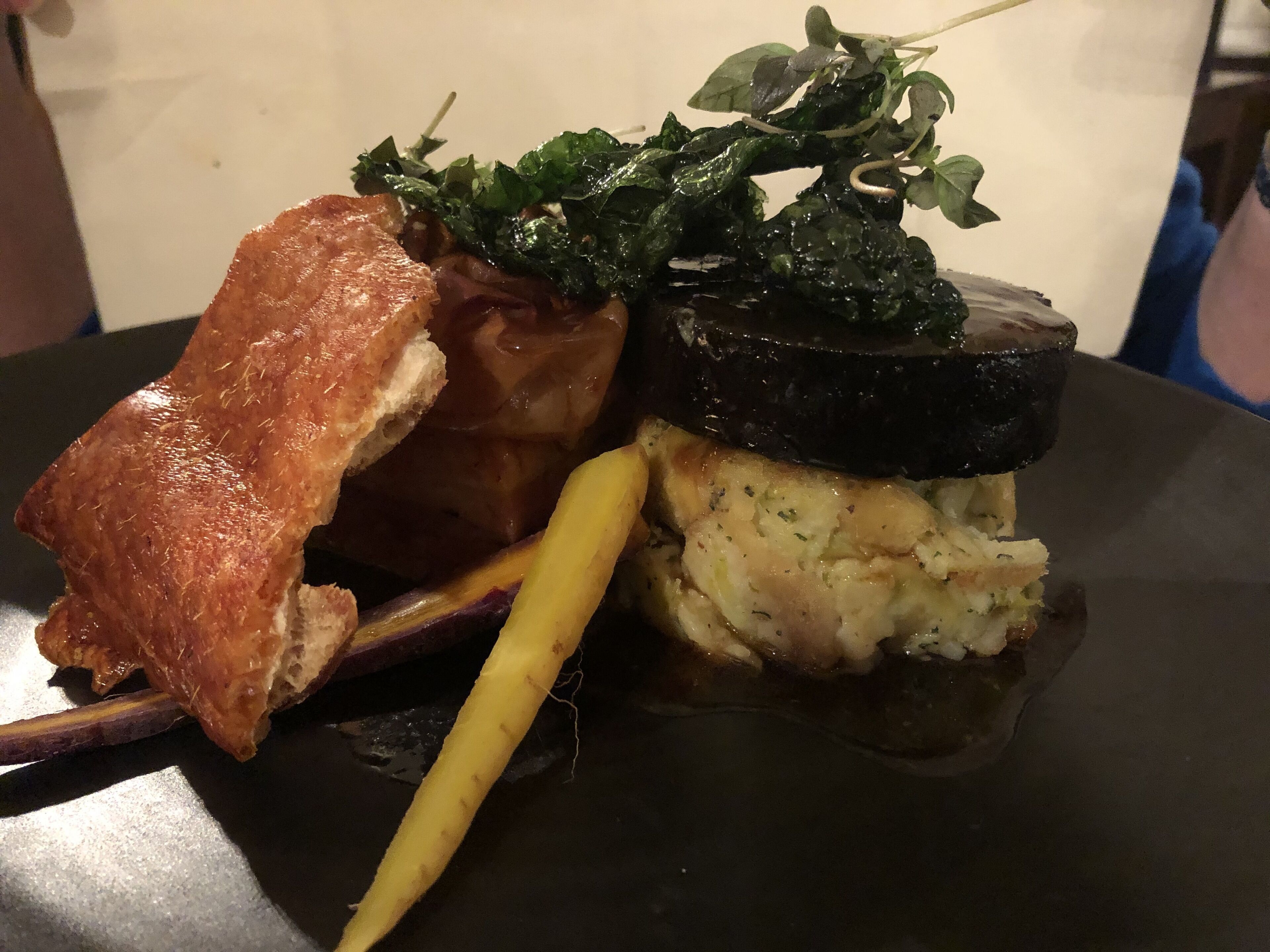 Un sándwich con rebanada de pan, carne y vegetales en un plato.