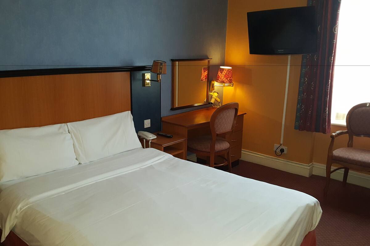 Desk, iron/ironing board, bed sheets