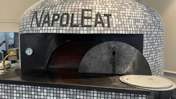 A pizza oven with a mosaic dome and the word "NAPOLLET" on it.