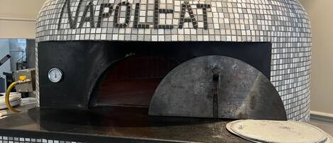 Un horno de pizza con cúpula de mosaico y la palabra 'NAPOLLET' escrita en él.
