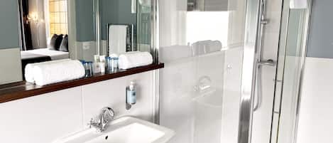 A modern bathroom with a glass-enclosed shower, a white sink, and a mirror above the sink.