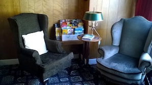 A room with two armchairs, a small wooden table with a lamp, and a box of board games. - The Albert Hotel Near Winter Gardens (Blackpool)