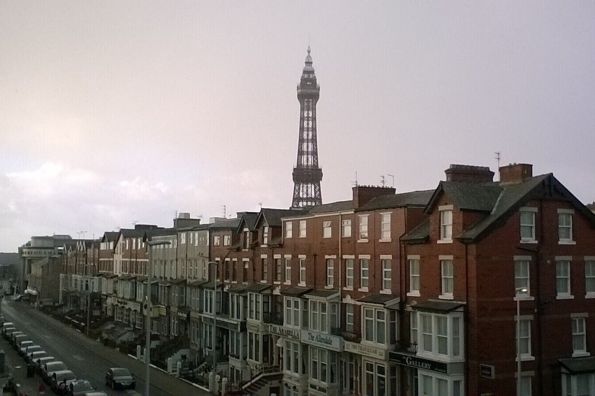 A row of terraced houses with a prominent tower in the background.