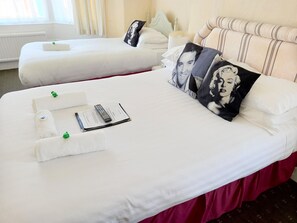 Two neatly made beds with white linens, pillows with a black and white design, and a remote control on the bed. - The Albert Hotel Near Winter Gardens (Blackpool)