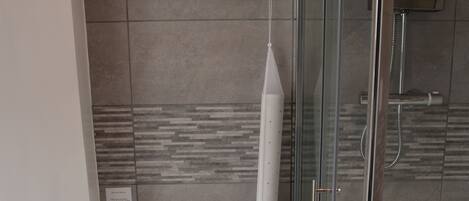 A modern bathroom with a toilet, bidet, and glass shower enclosure.