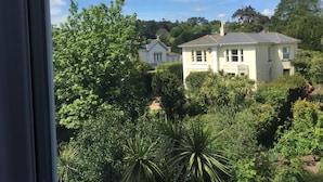 A house surrounded by lush greenery and a clear blue sky. - Acorn Lodge (Torquay)